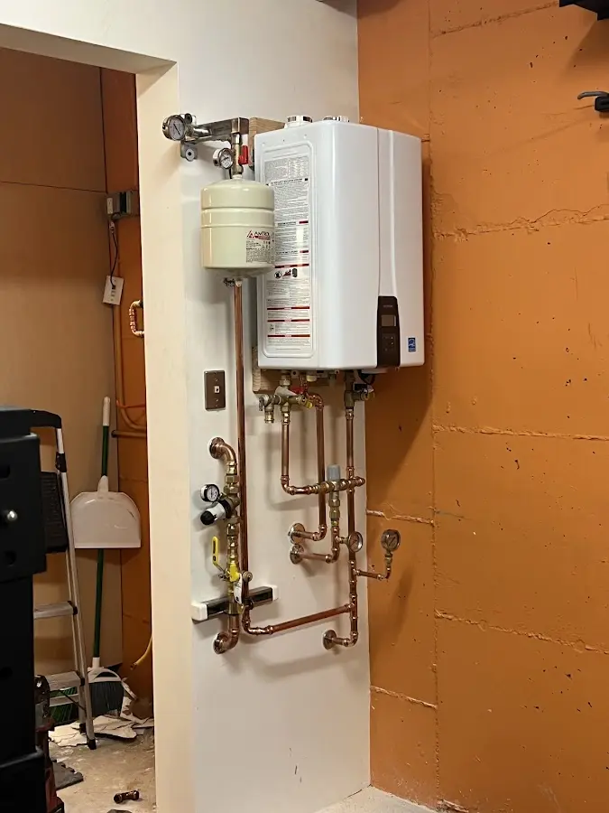 Plumbing technician inspecting water heater connections in Carlsbad